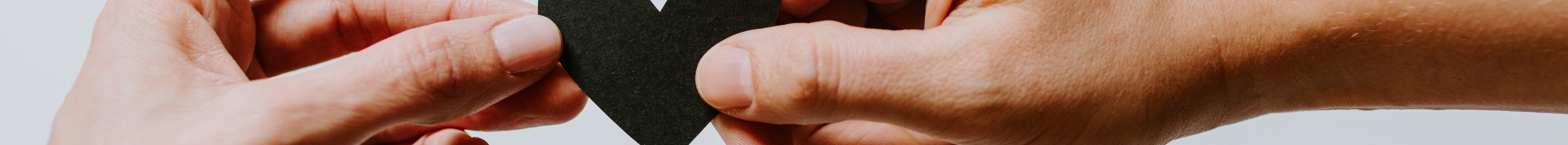 two person holding papercut heart