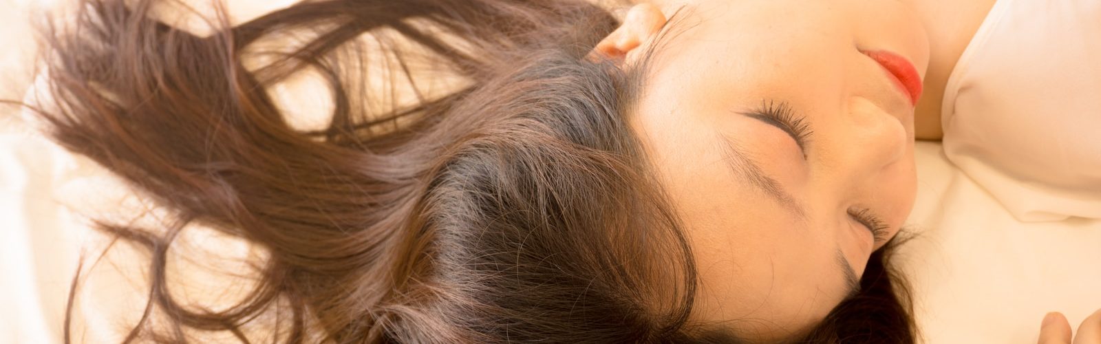 woman lying on white bed