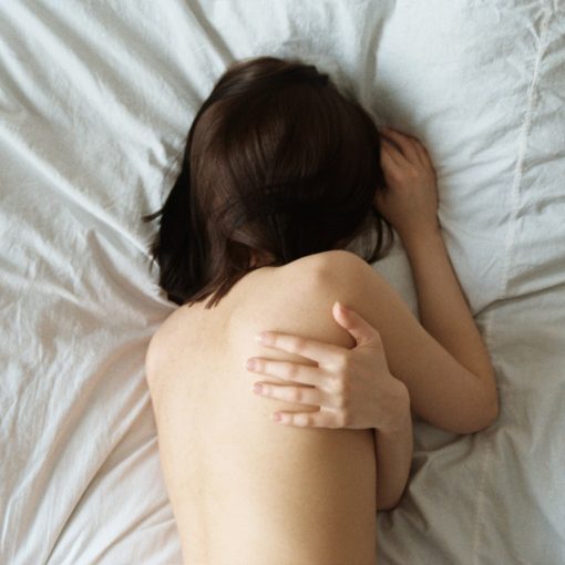 woman lying on white bed