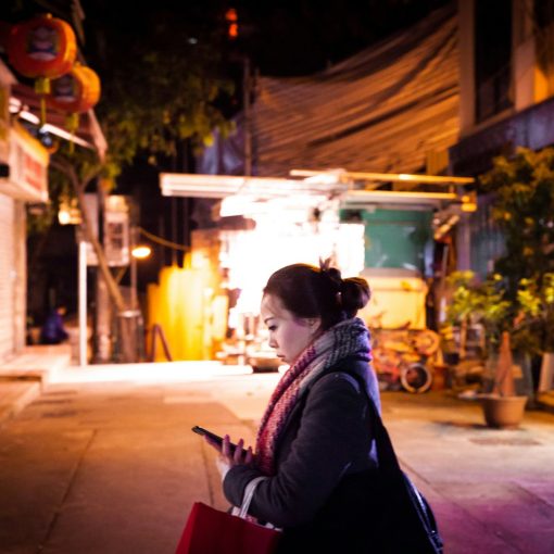 woman in black jacket sitting on red chair during night time