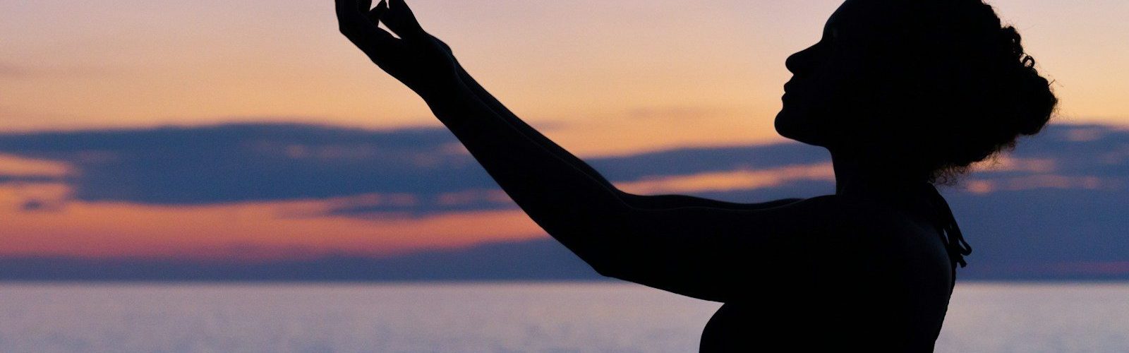 silhouette of woman raising her right hand