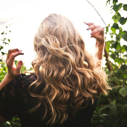 blonde haired woman in black top surrounded by tall plants