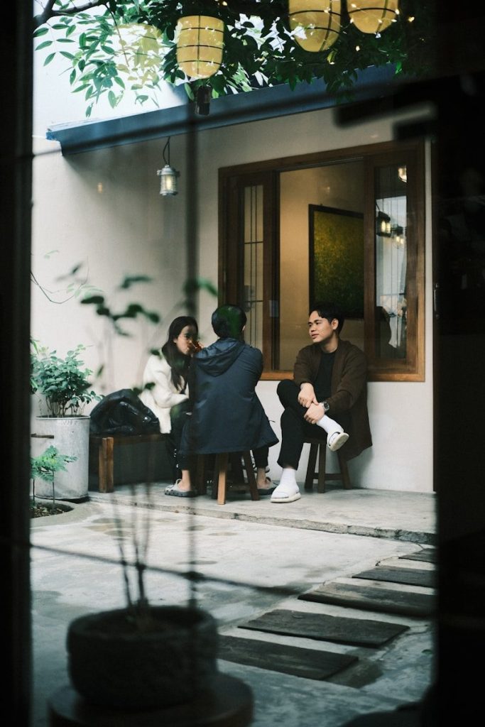 A group of people sitting outside of a house
